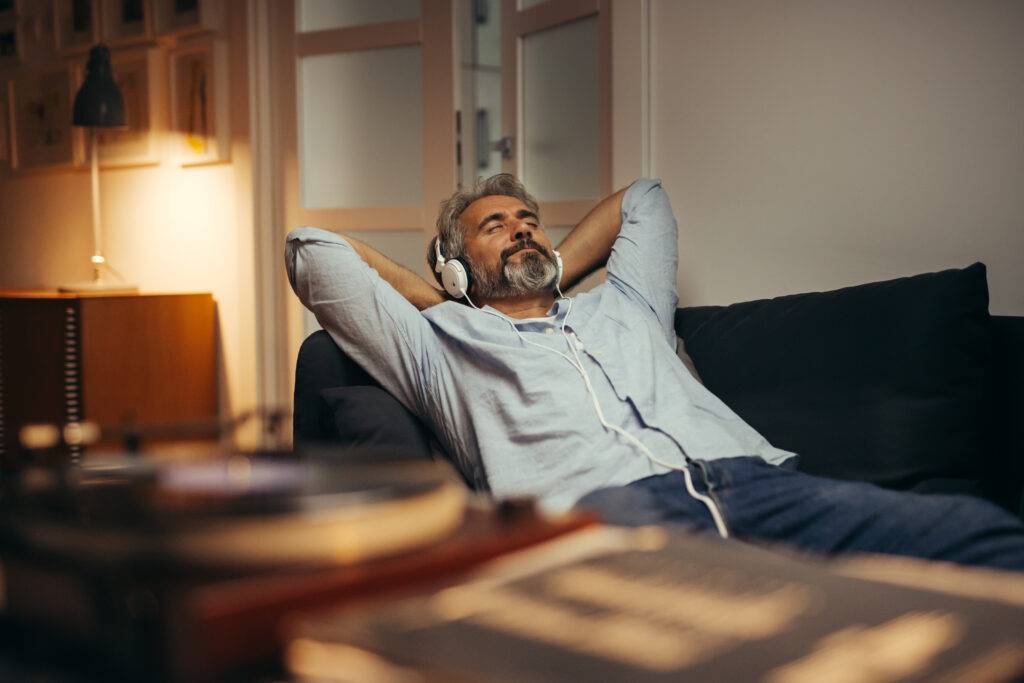 Mid,Aged,Man,Listening,Music,With,Headphones,On,Phonograph,,Relaxed