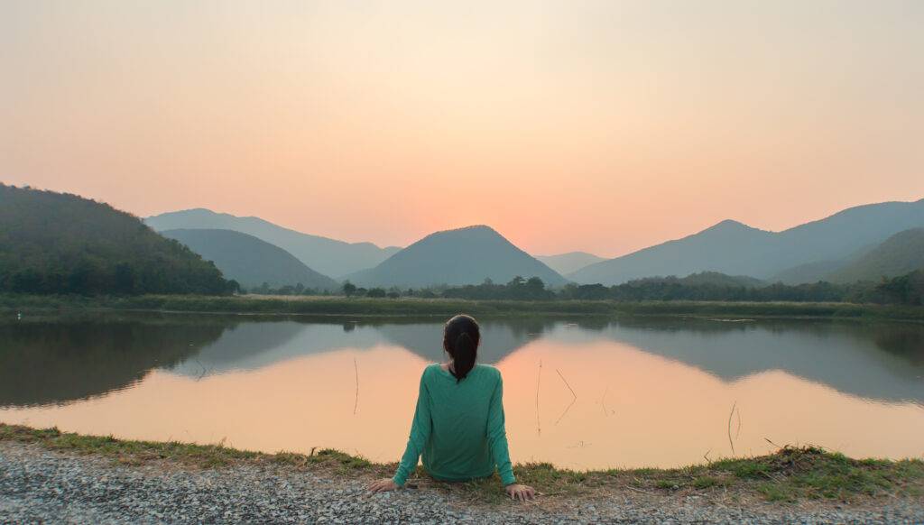 Social,Distancing,,A,Woman,Is,Sitting,Alone,By,The,Lake